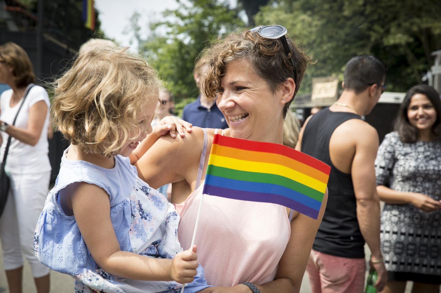 Berlin: Ein kleines Mädchen auf dem Arm seiner Mutter mit einer LGBT-Fahne in der Hand