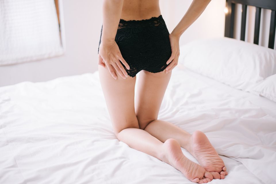 Cellulite-Behandlung: Frau in Unterhose auf dem Bett