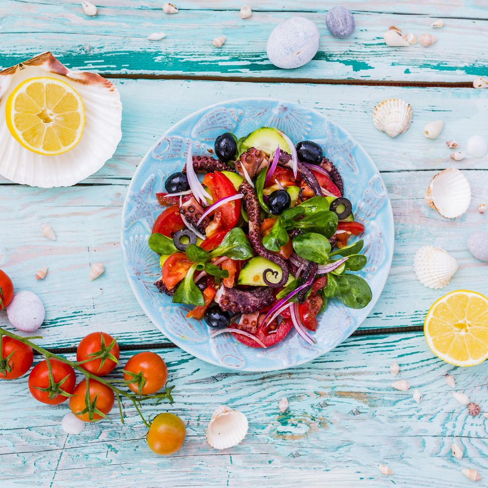 Mittelmeerdiät: Muscheln, Zitronen, Tomaten und ein Teller mit Salat und Octopus