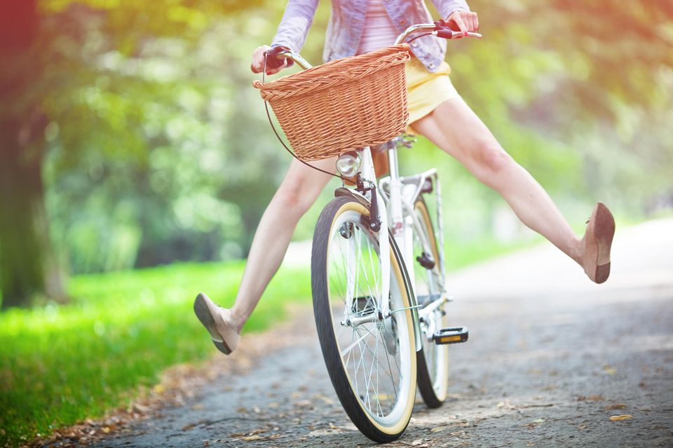 Glück: Frau auf dem Fahrrad fährt bergab
