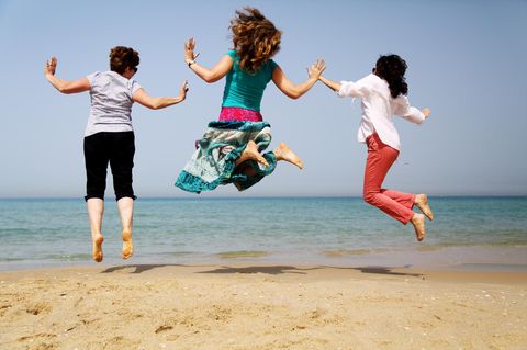 Abnehmen ab 50: Drei Frauen am Meer hüpfen in die Luft