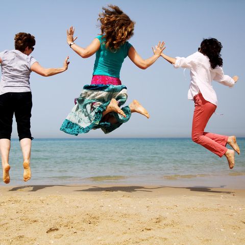 Abnehmen ab 50: Drei Frauen am Meer hüpfen in die Luft