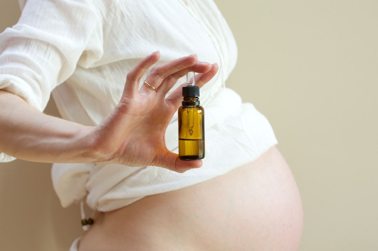 33. SSW: Schwangere hält Ölfläschchen für Dammmassage