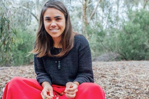 Weltfrauentag: Eine junge Frau sammelt Blätter im Wald