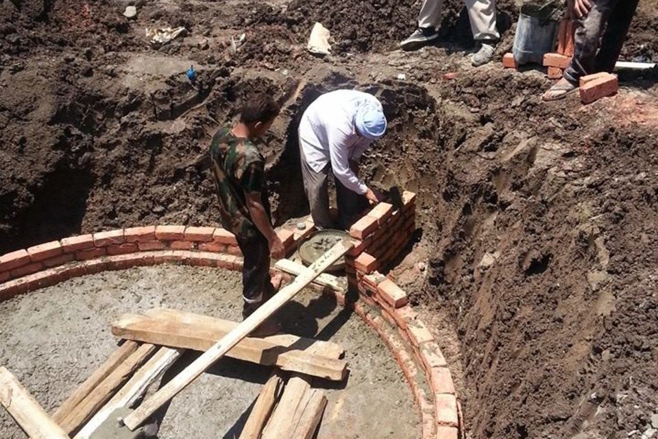 Drei Männer auf der Baustelle einer "Biogas-Anlage" in Ägypten