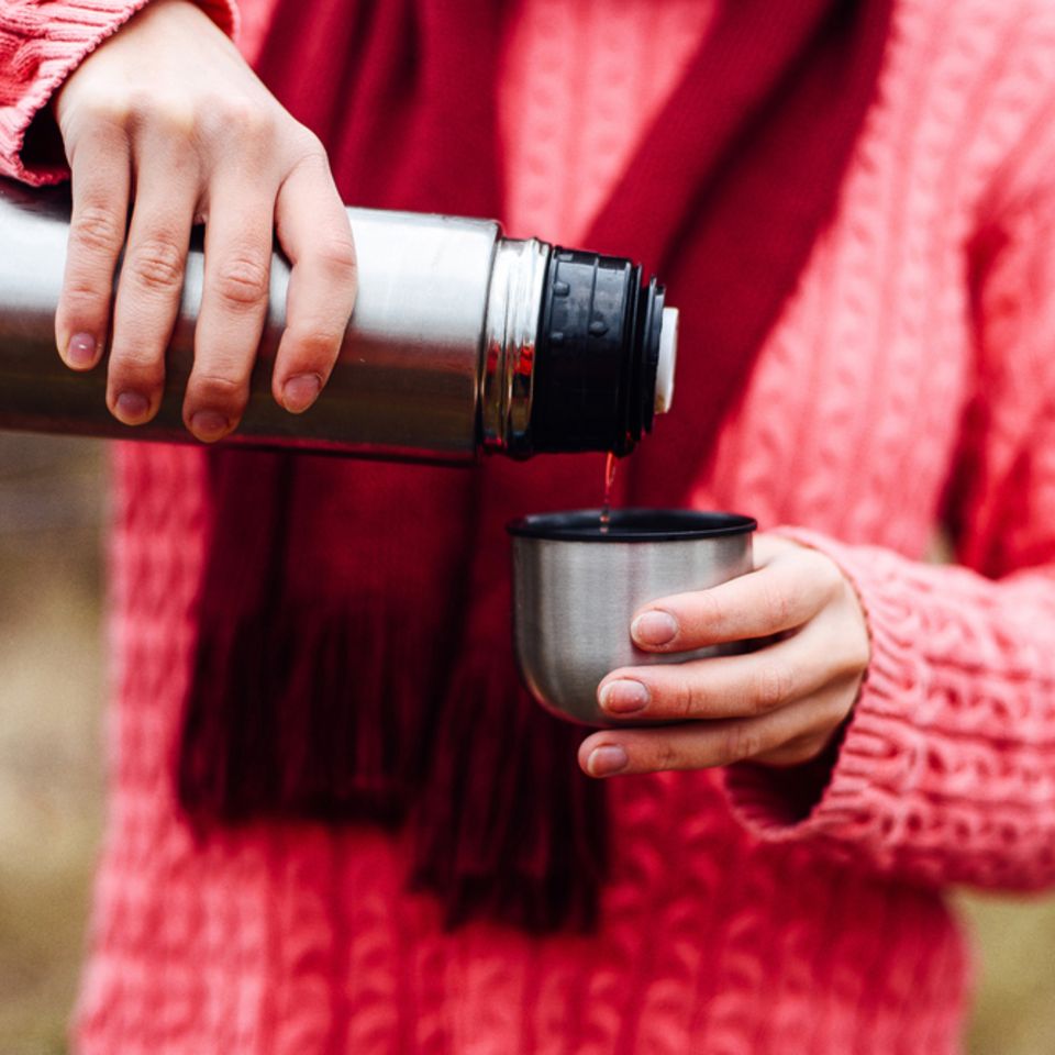 Thermoskanne reinigen: Frau mit Tee