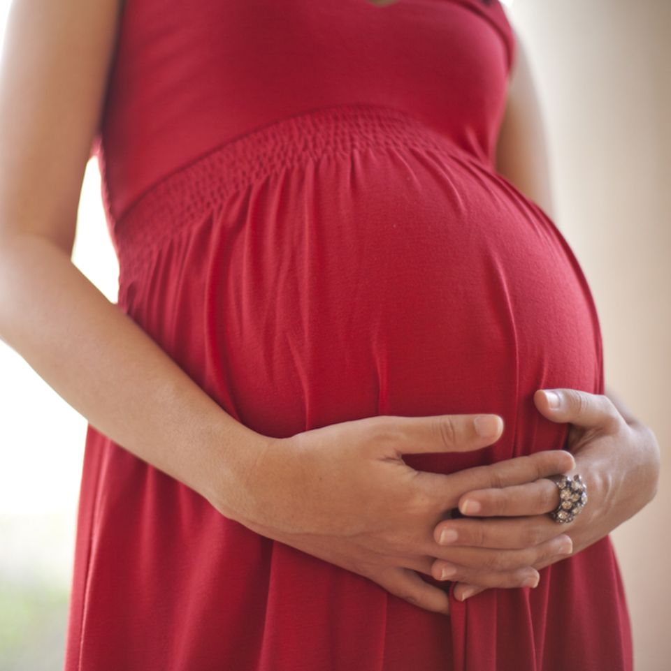 35. SSW: Schwangere Frau hält ihren Bauch