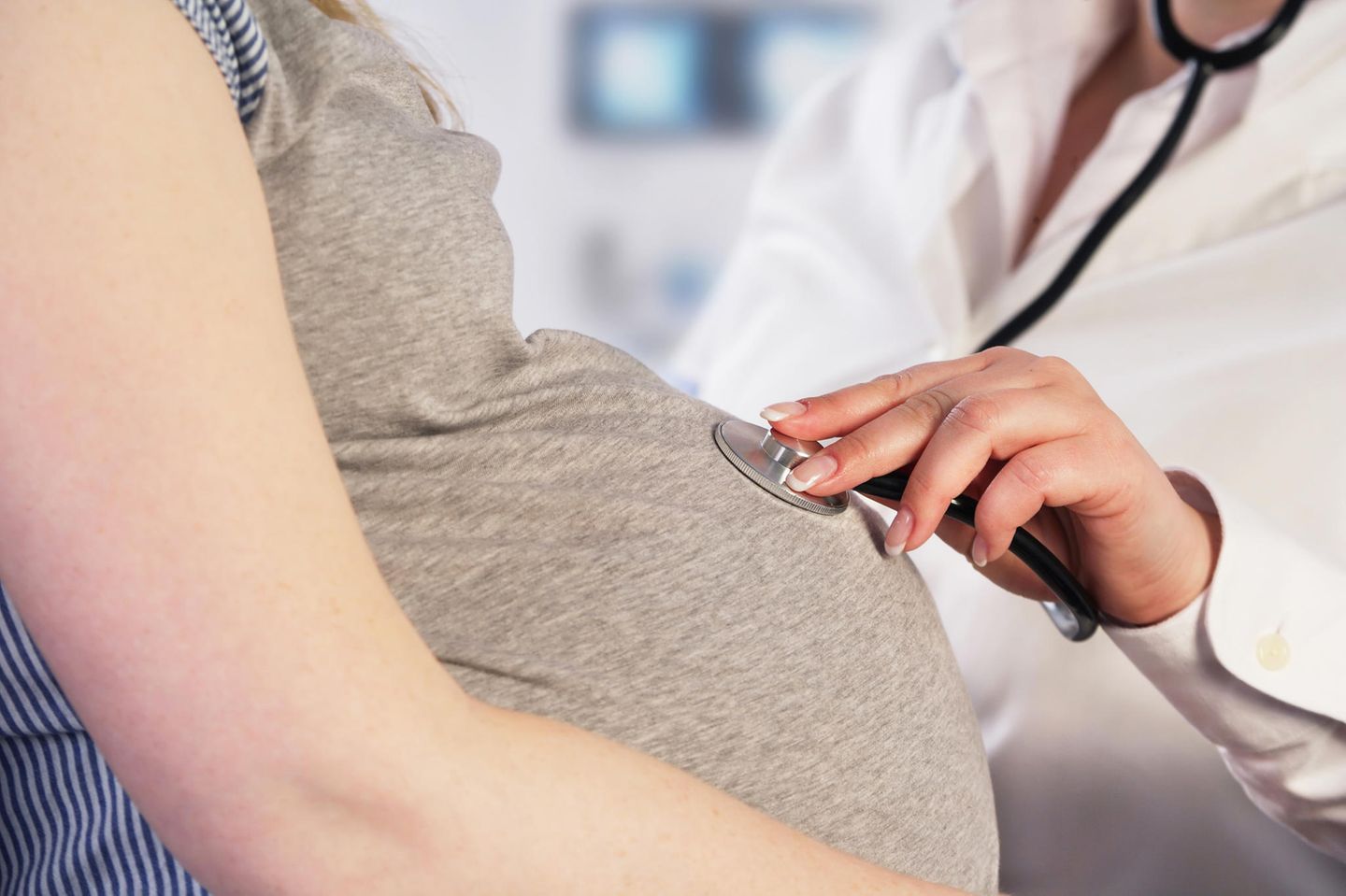 Gynäkologe hört den Bauch einer Hochschwangeren ab