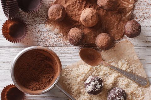 Pralinen selber machen: Trüffel mit Kakaopulver auf Arbeitsplatte