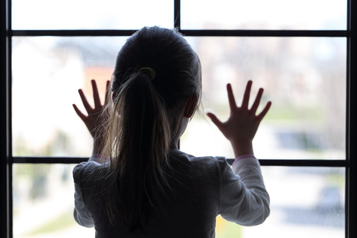 Cottbus: Ein Mädchen steht am Fenster
