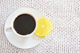 Kopfschmerzen: Eine Tasse Kaffee, daneben eine Zitrone