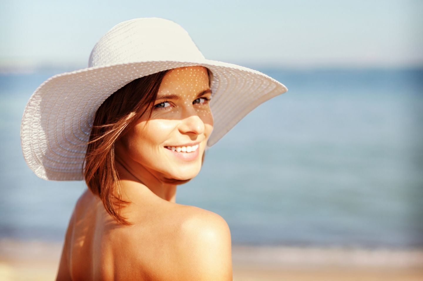 LSF 50: Frau mit Hut am Strand