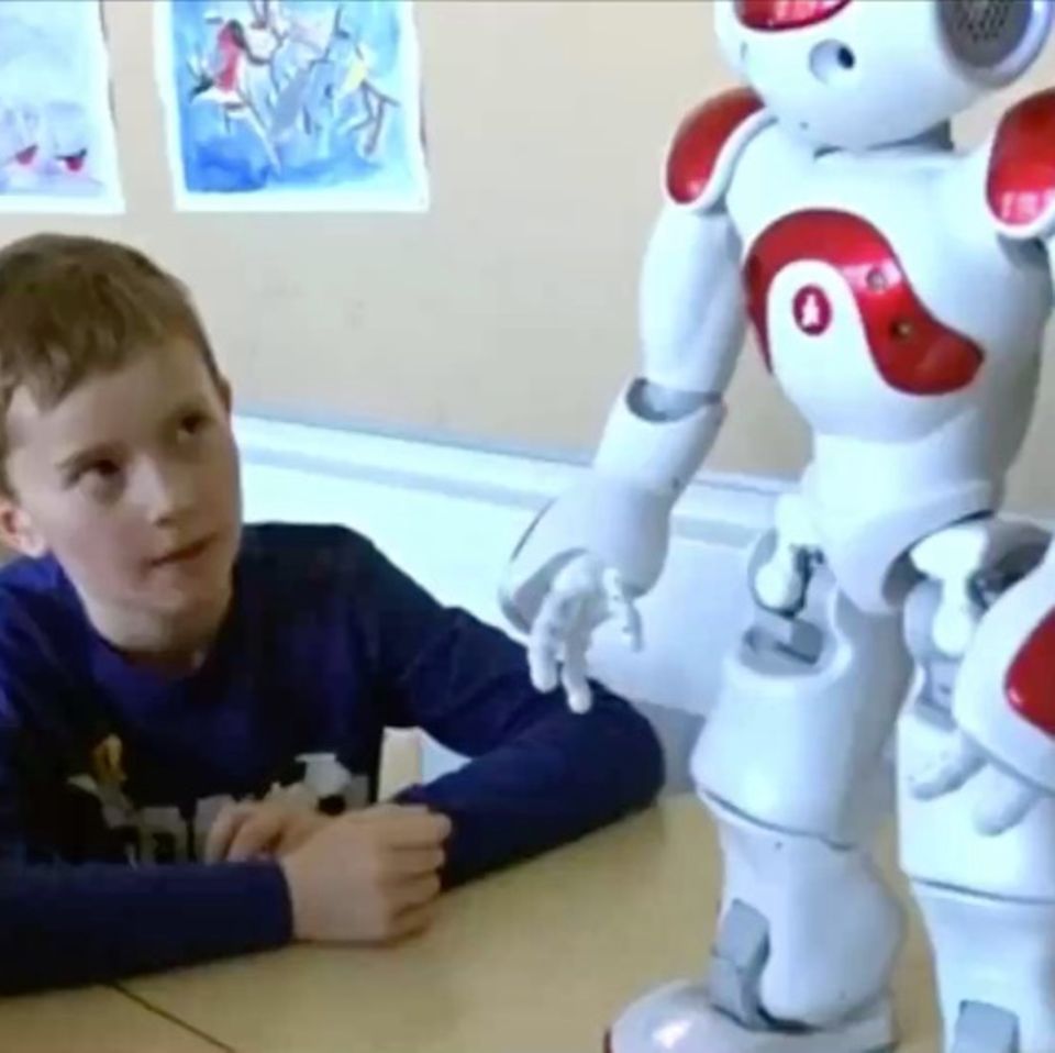 Roboter in der Grundschule: Schüler guckt aufmerksam zu Roboter
