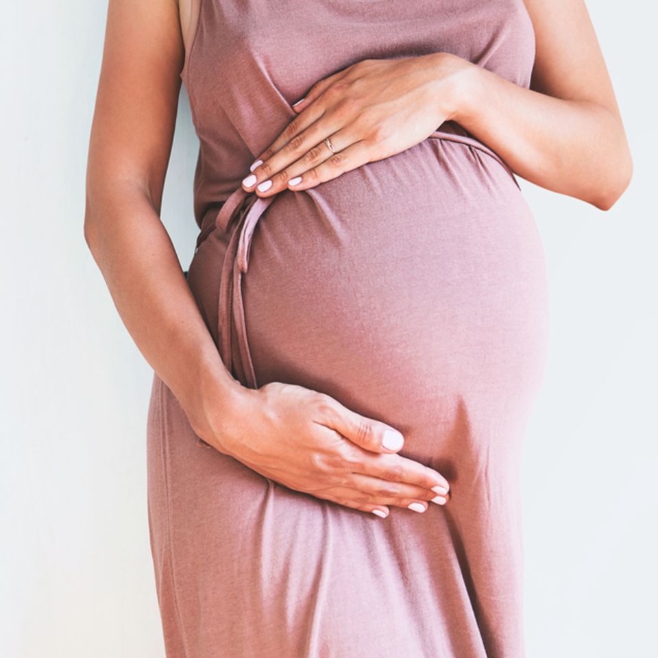 40. SSW: Frau hält schwangeren Bauch