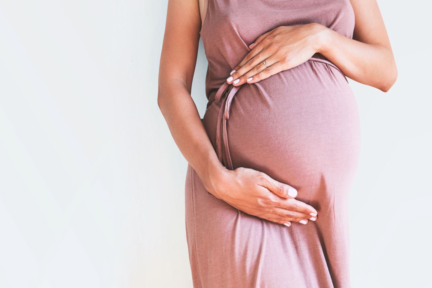 40. SSW: Frau hält schwangeren Bauch