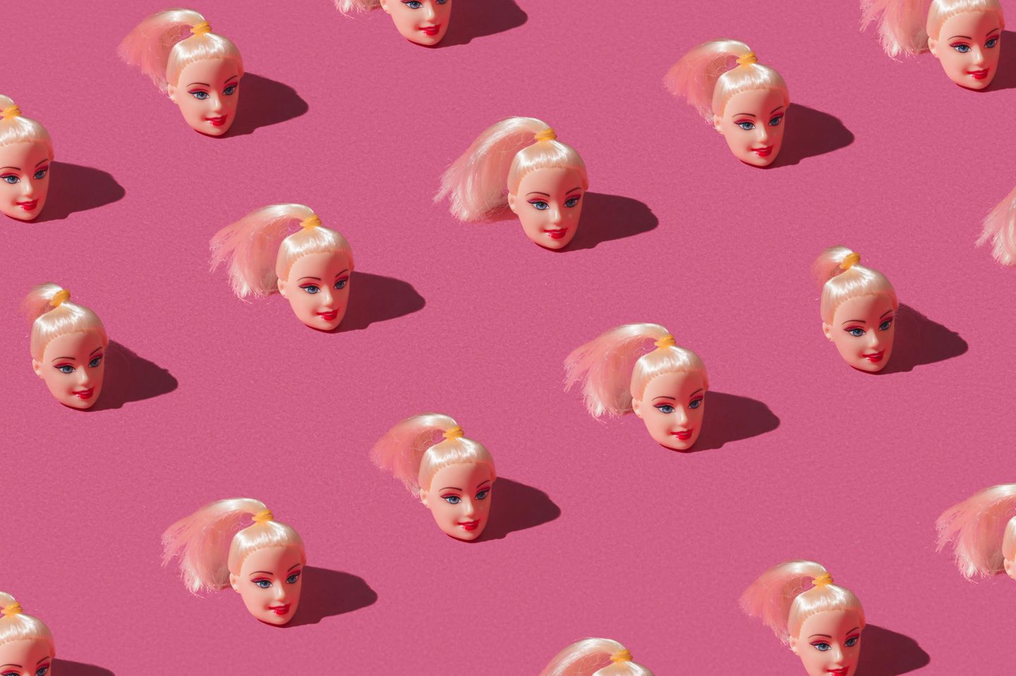 Barbie-Köpfe auf rosa Untergrund