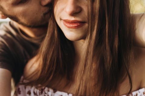 Glückliche Beziehung: Mann küsst Frau auf die Wange