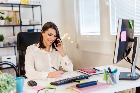 Frau telefoniert bei der Arbeit