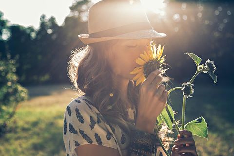 Duft-Unverträglichkeit: Frau riecht an einer Sonnenblume