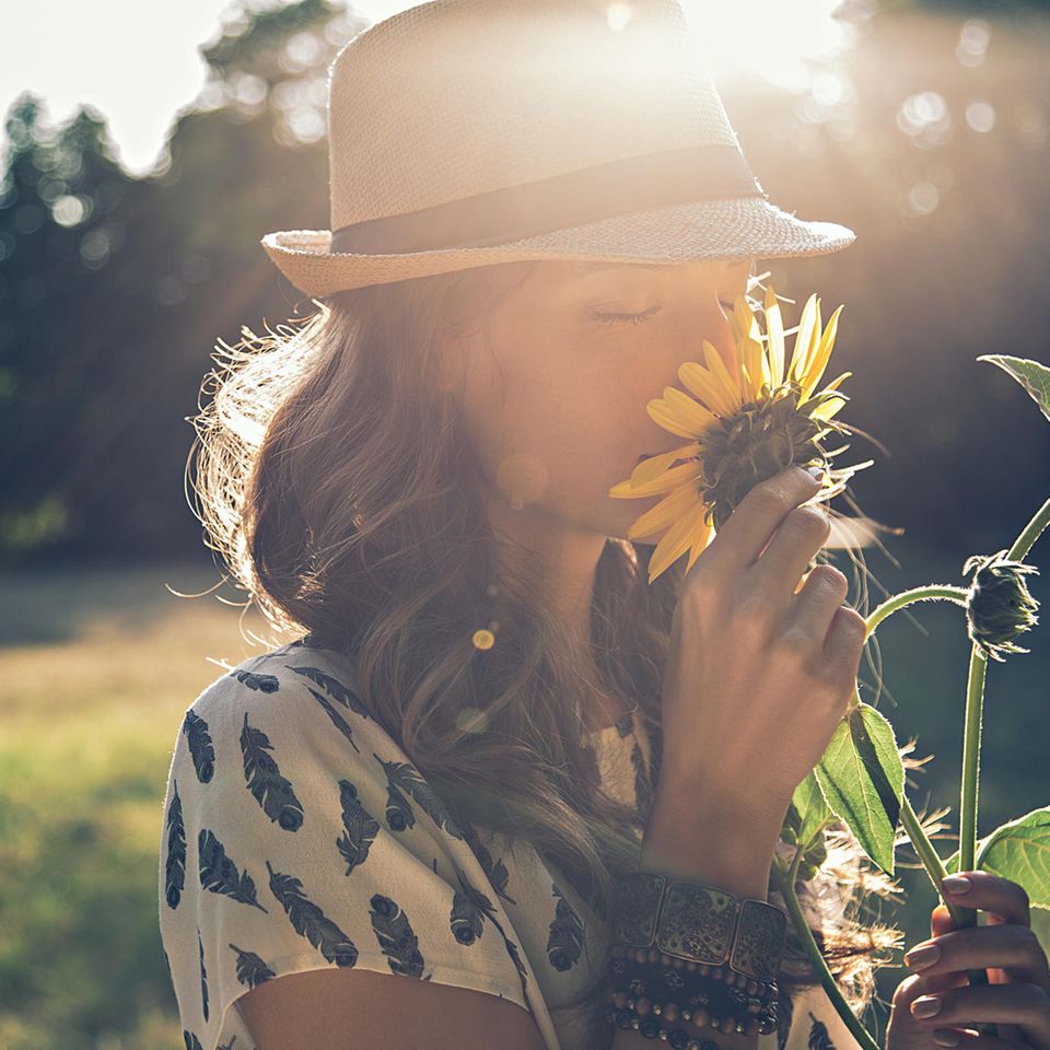 Duft-Unverträglichkeit: Frau riecht an einer Sonnenblume