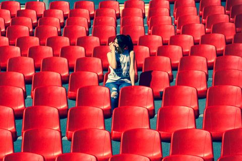 Alleine ausgehen: Frau sitzt in leerem Publikum