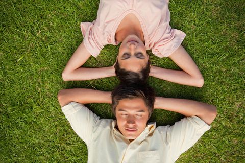 Männliches, weibliches Gehirn: Mann und Frau liegen im Gras