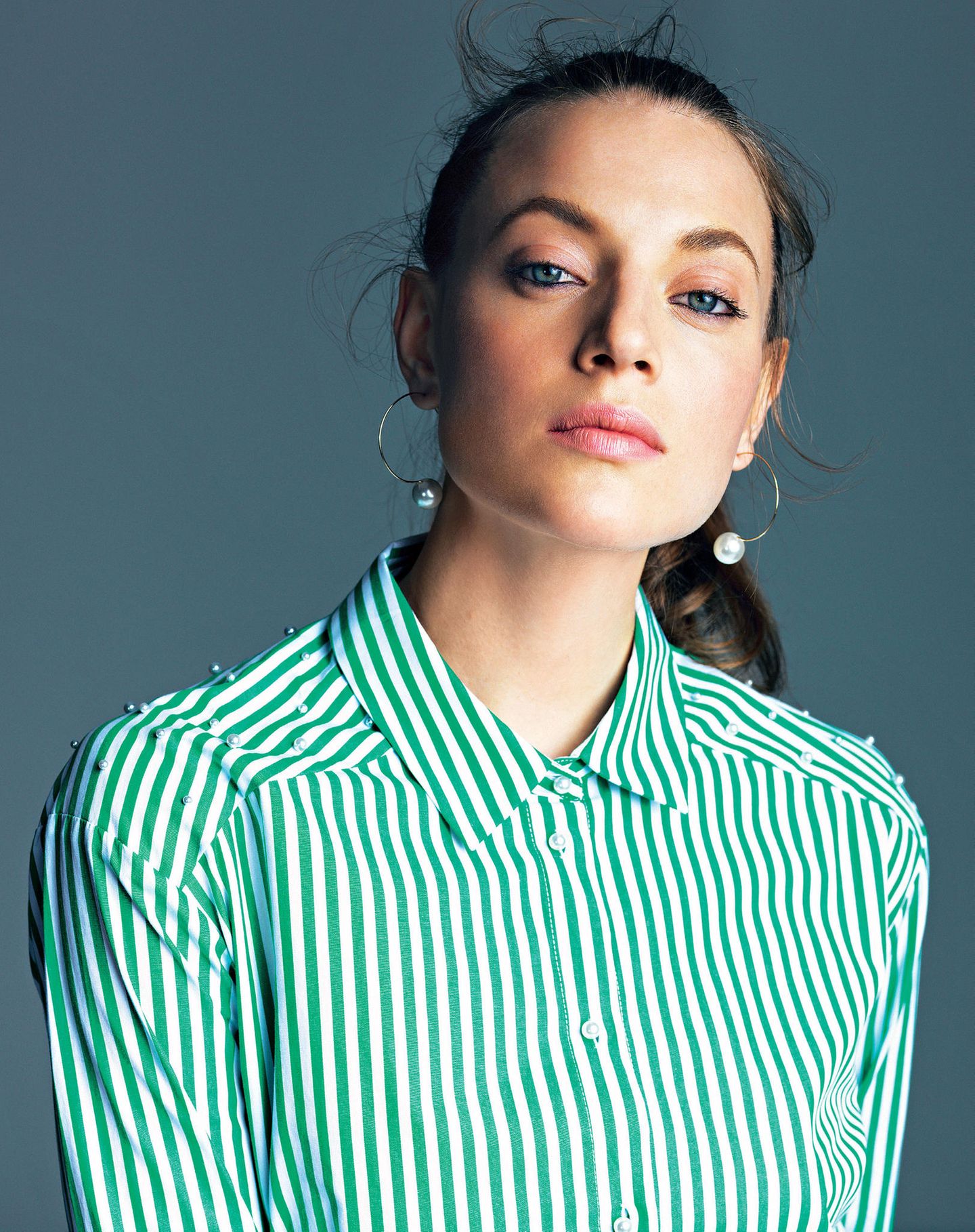 Sommertrends 2018: Model im Porträt mit gestreifter Bluse in grün und weiß.