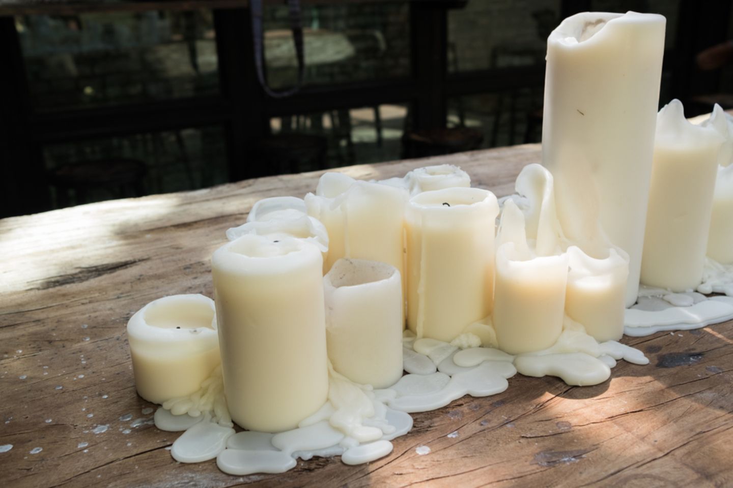 Wachsflecken entfernen: Geschmolzene Kerzen auf dem Tisch