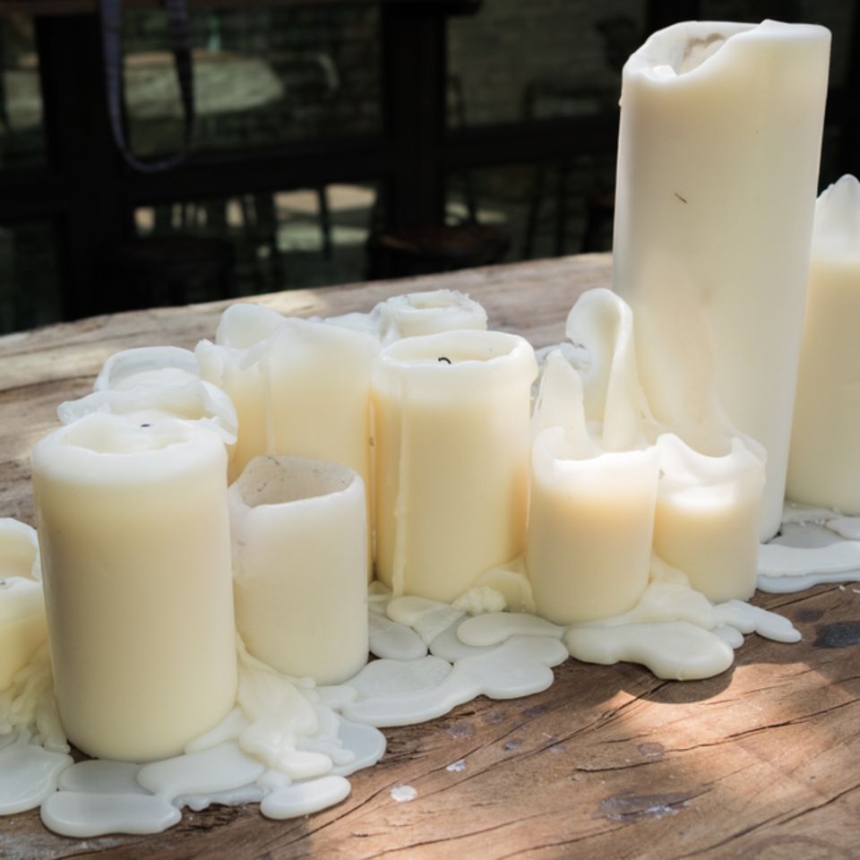 Wachsflecken entfernen: Geschmolzene Kerzen auf dem Tisch