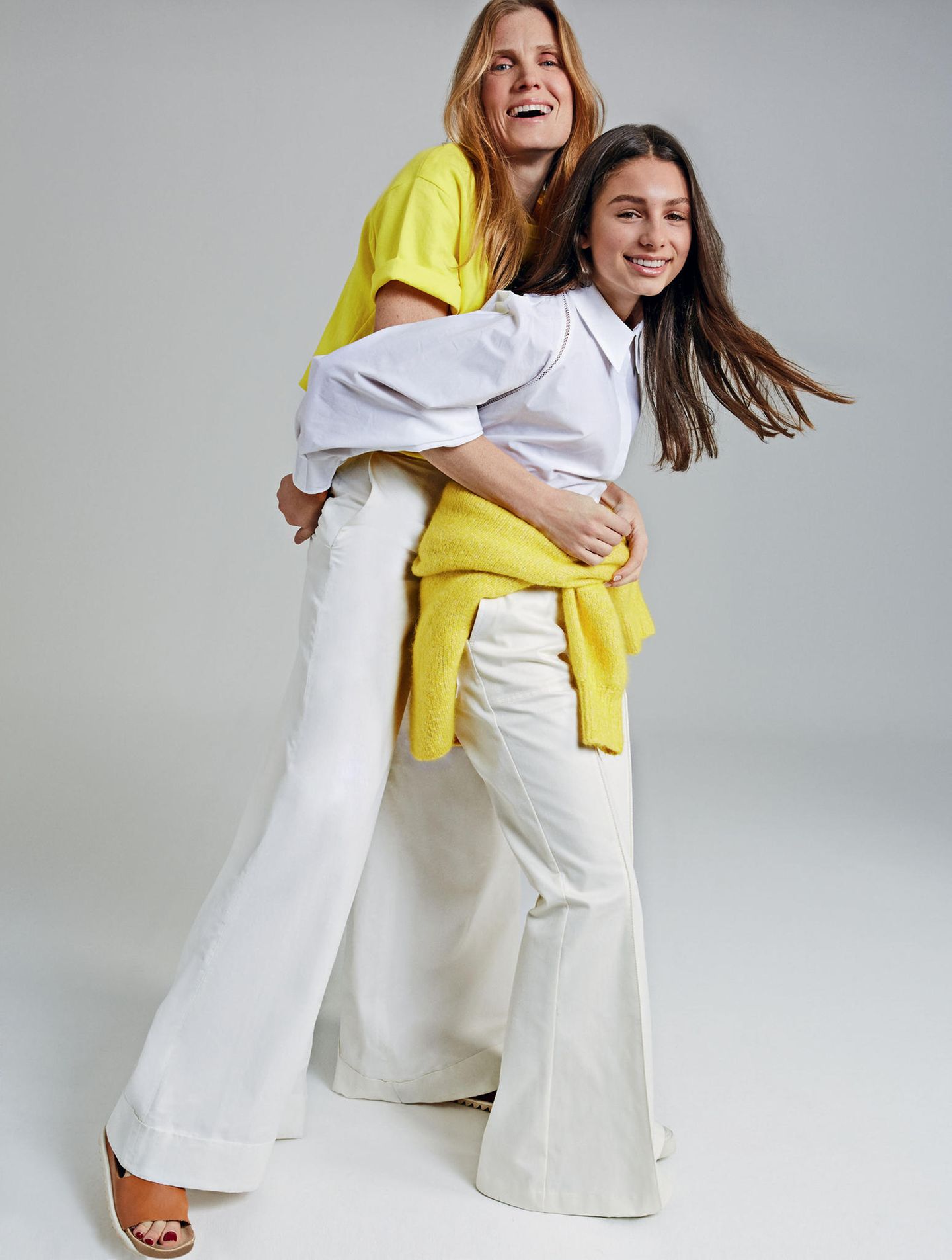 Mutter-Tochter-Looks: Mutter und Tochter in weißen Outfits mit jeweils einem knallgelben Teil