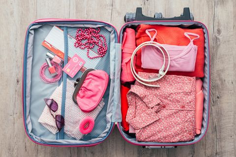 Koffer packen: Koffer mit Kleidung drin