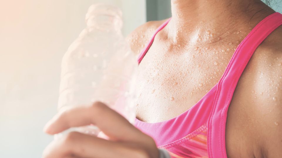 Lebensmitttel gegen Schwitzen : Frau mit Wasserflasche