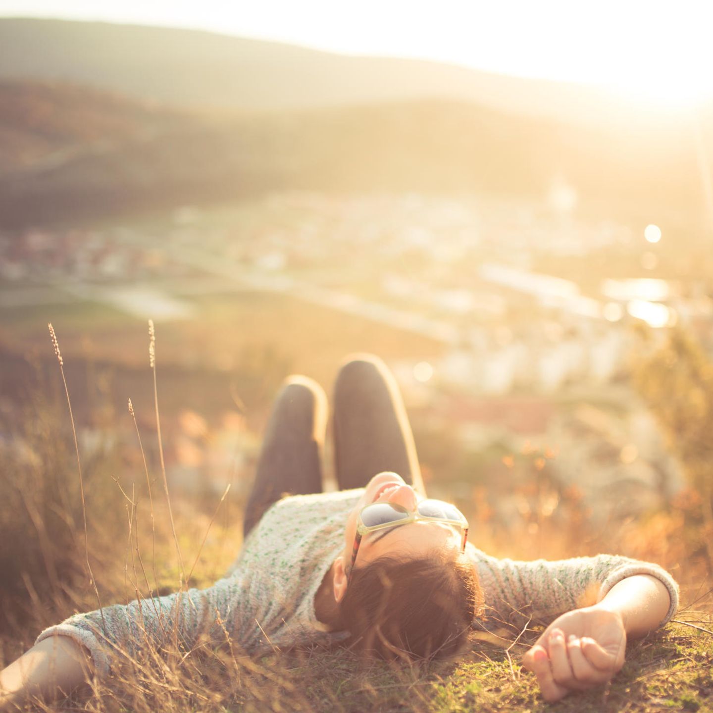 gesund leben: Frau entspannt auf einem Hügel