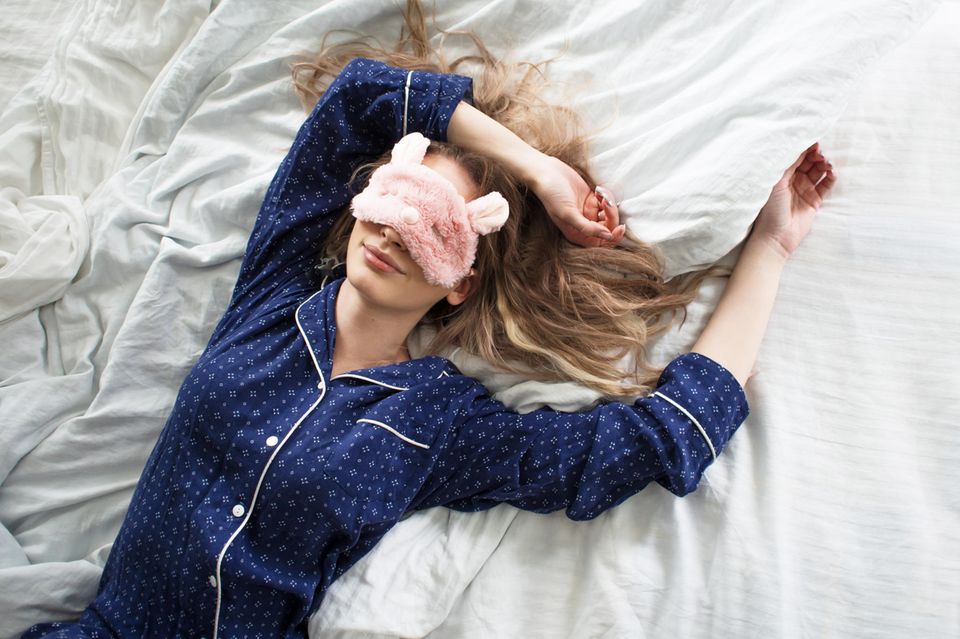 Schnell einschlafen: Frau mit Pyjama und Schlafbrille