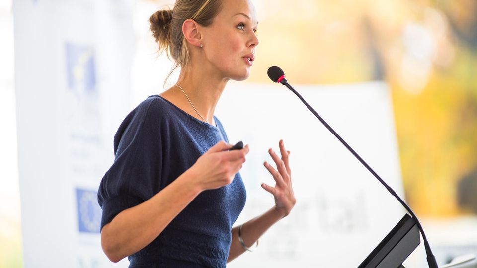 5 Tipps für eine selbstbewusste Körpersprache: Frau hält eine Rede