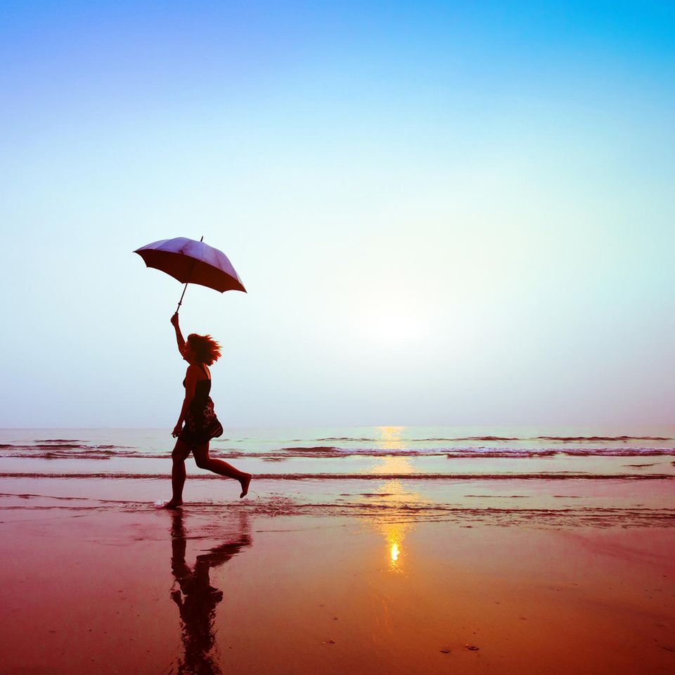 Versicherung im Alter: Frau läuft am Strand