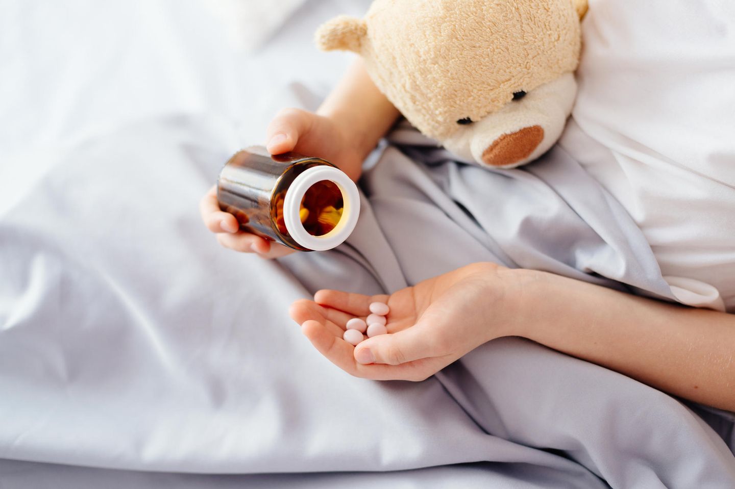 Vater gibt Kindern keine Medizin: Kinderhände mit Tabletten