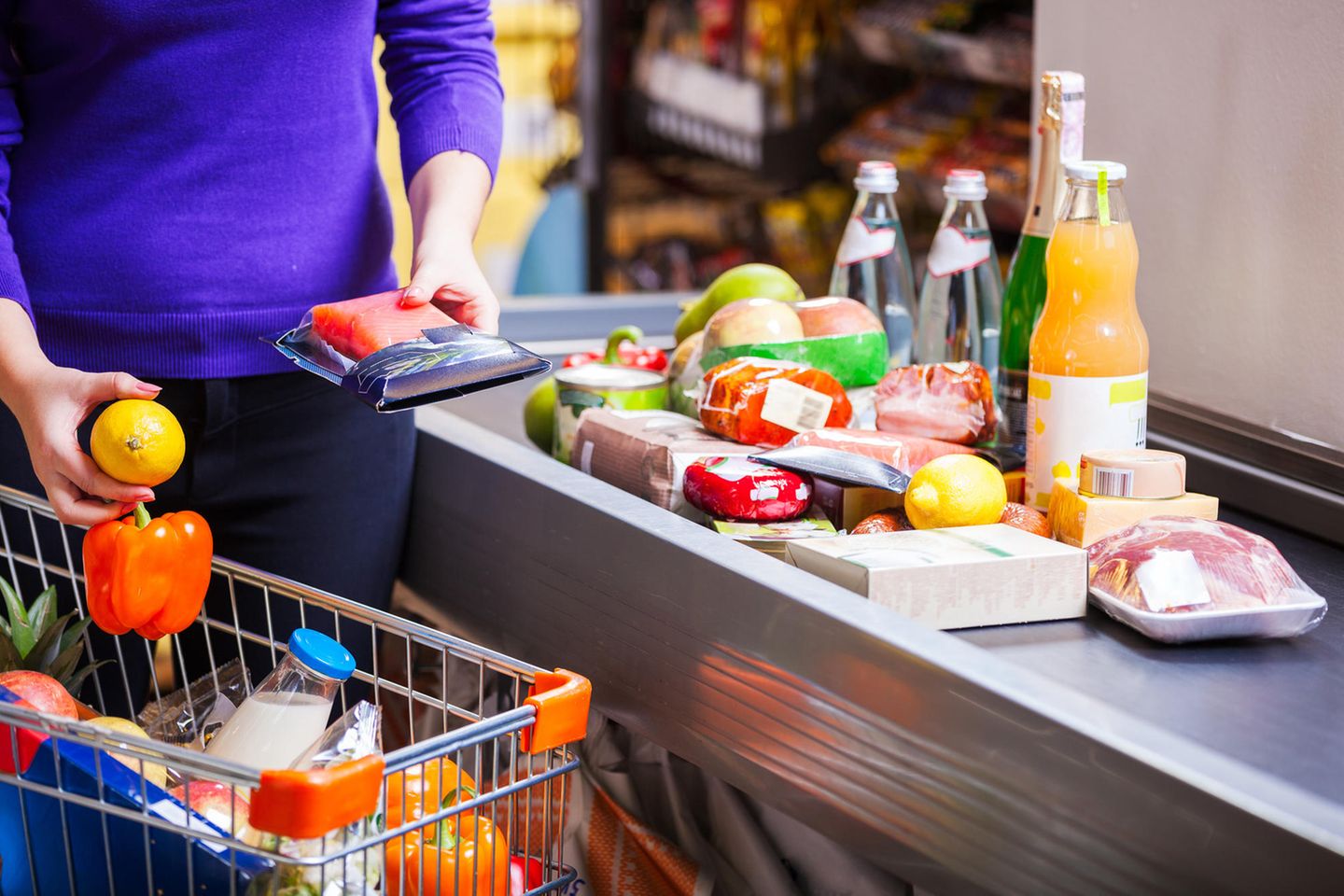 Clever einkaufen im Supermarkt: Frau steht an der Kasse