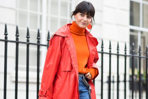 Frau mit rotem Mantel, Pullover in Orange und Schuhen in Lila