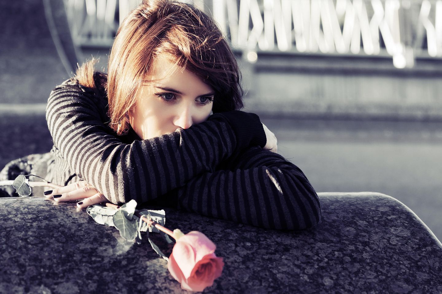 Herz gebrochen: Eine traurige junge Frau mit Rose in der Hand