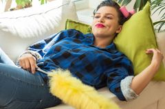 Defermentitis: woman lying on the couch with a feather duster