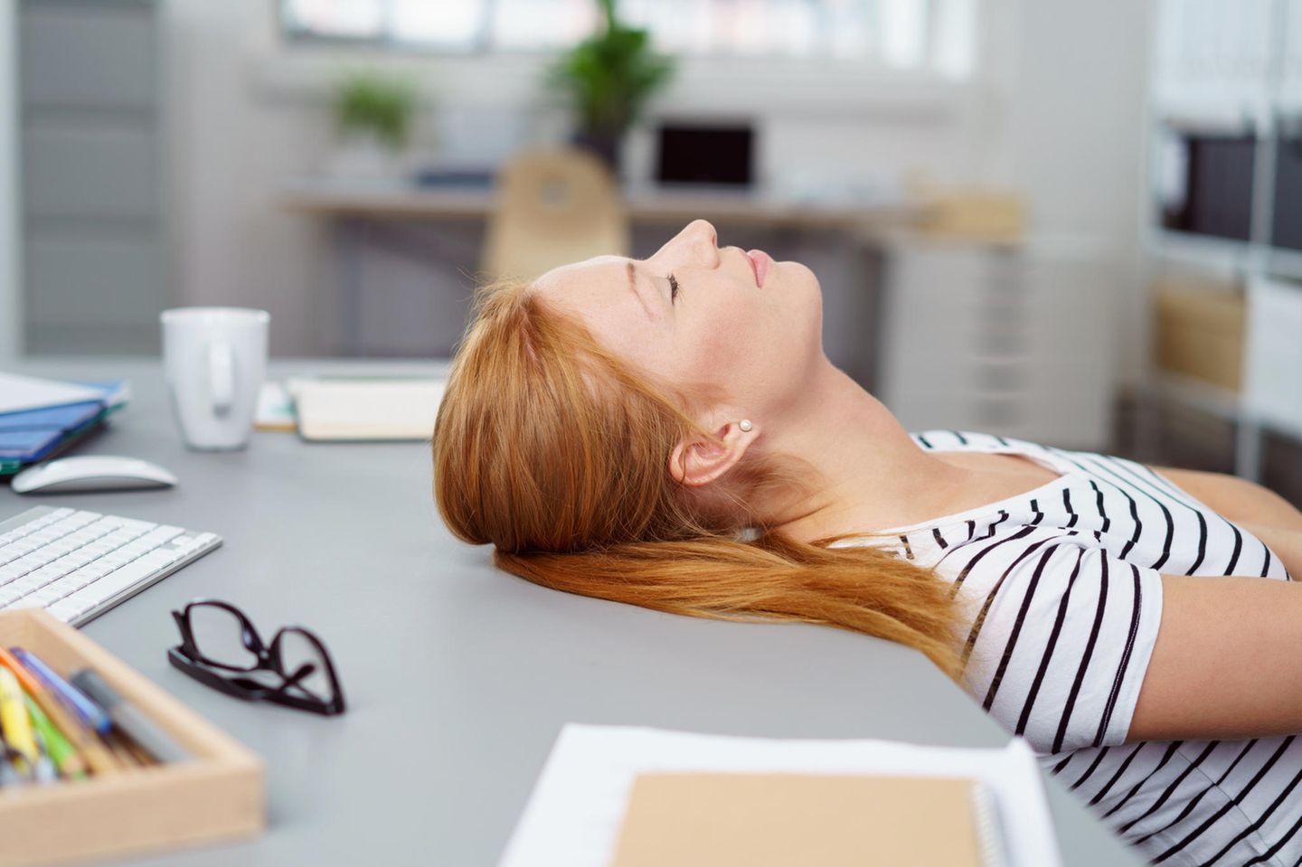 Montagsblues: Frau erschöpft am Schreibtisch