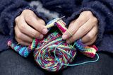 Herbst-Ideen: Frau strickt mit Nadeln und Wolle