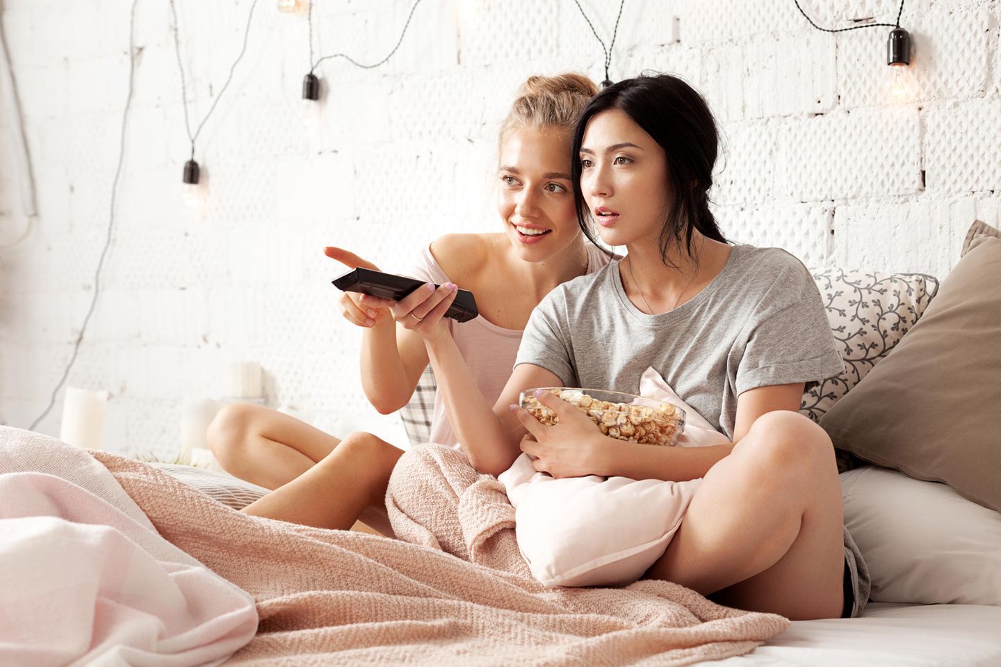 Herbst-Ideen: zwei Frauen sitzen auf der Couch und schauen Fernseh