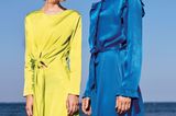 Zwei Frauen mit Kleidern aus Satin in blau und gelb