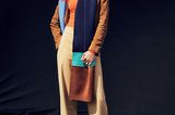 Frau trägt camelfarbenen Mantel und bunten Schal