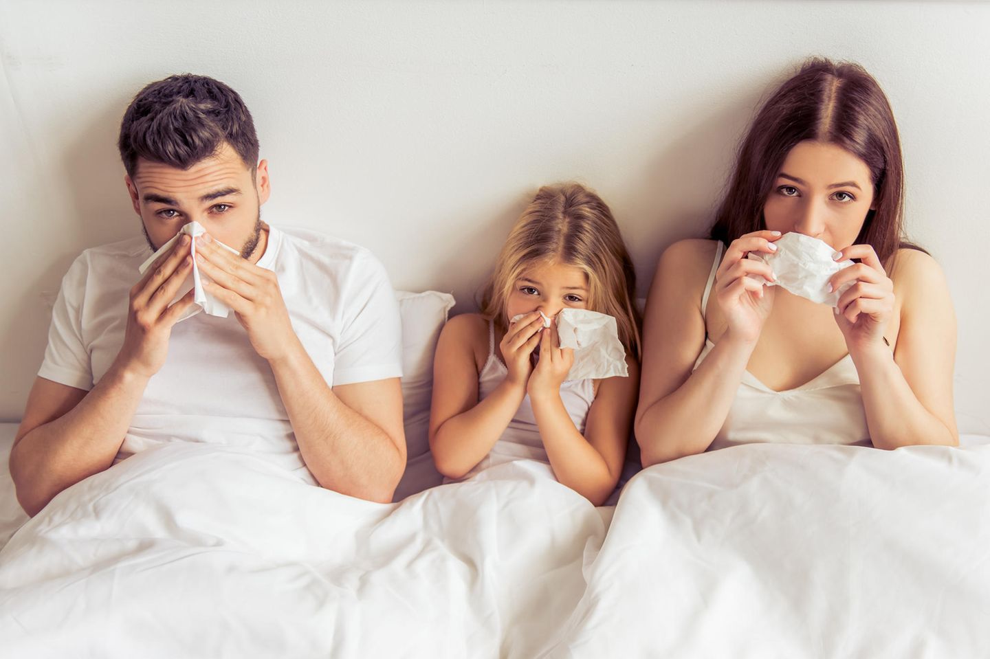 Dauererkältung: Kranke Familie im Bett