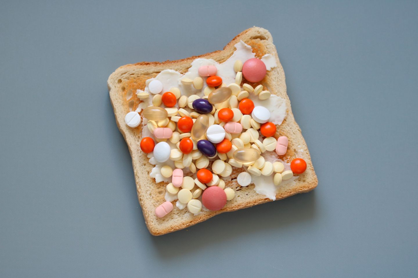 Nahrungsergänzungsmittel: Viele Pillen auf Brotscheibe