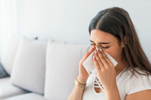 Chronischer Schnupfen: Frau putzt sich die Nase