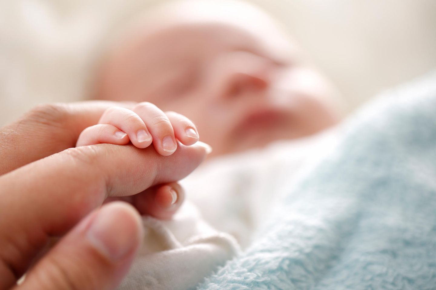 IVF-Babys: kleines Baby hält Hand von Mutter